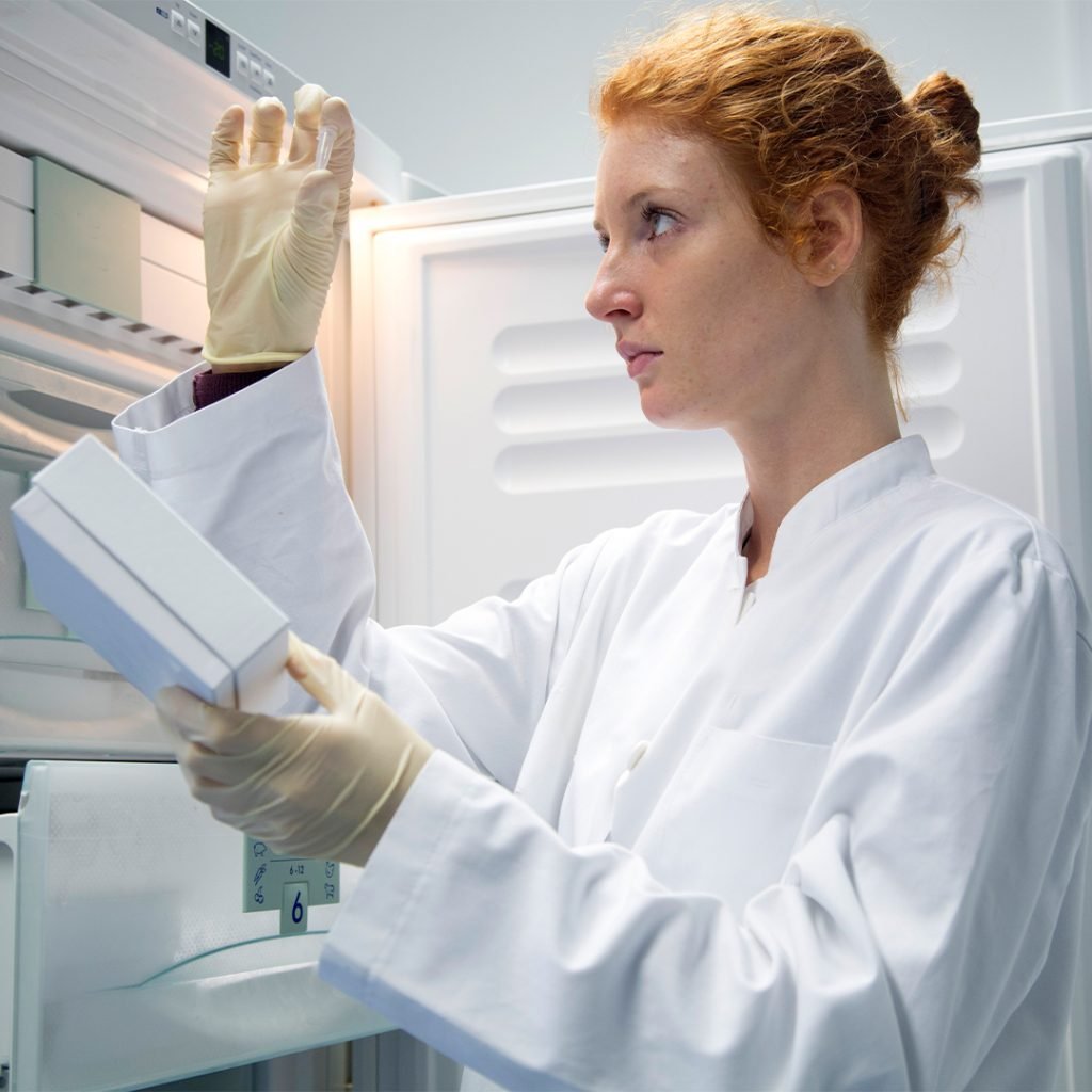 Lady in a lab examining a spore plate from a lab freezer